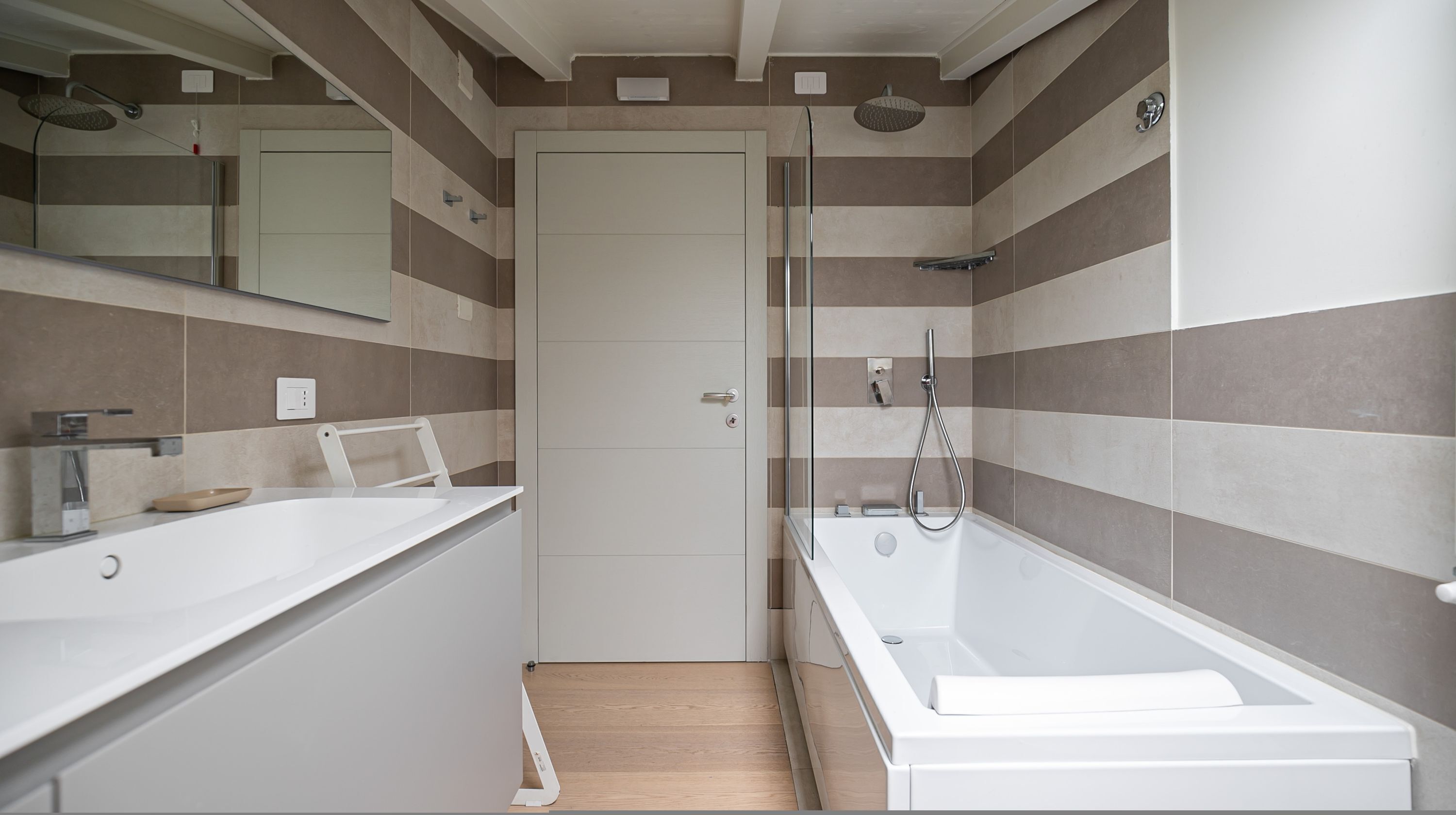 A modern bathroom with a shower, a bathtub, and a vanity with a mirror.