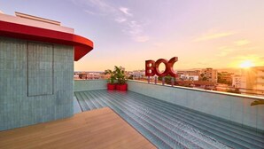 A rooftop terrace with a pool, potted plants, and a large 'BOX' sign. - The Boc Hostels Beach (Palma de Mallorca)