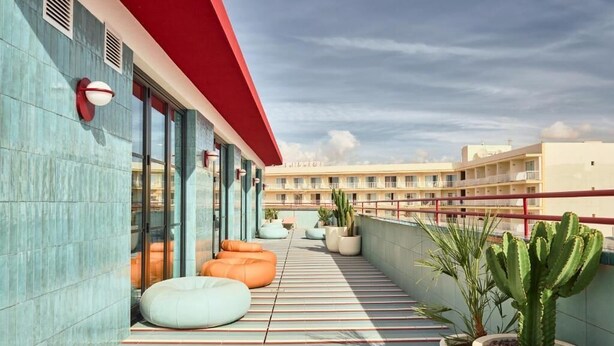 A rooftop terrace with striped flooring, potted plants, and outdoor seating. - The Boc Hostels Beach (Palma de Mallorca)