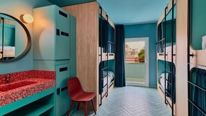 A compact hotel room with a herringbone floor, a red-speckled sink, a red chair, and a view through a glass door to the outside. - The Boc Hostels Beach (Palma de Mallorca)