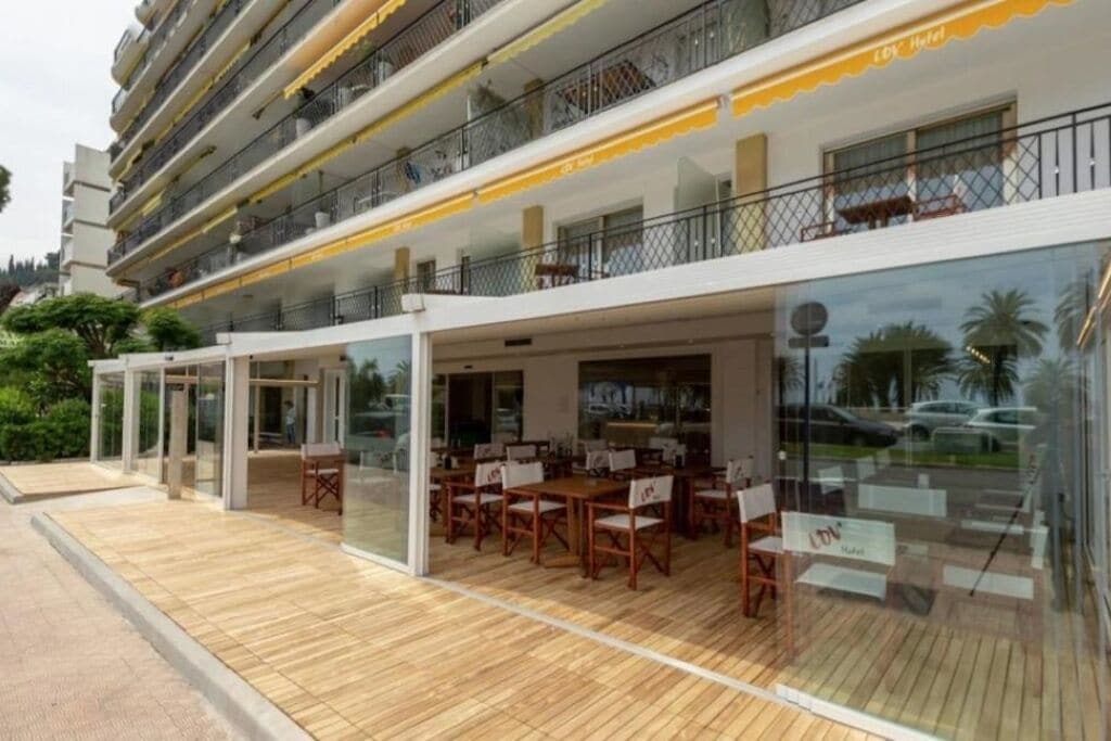 A hotel with outdoor seating, a pool, and a balcony with a view.