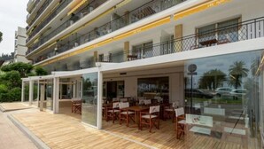 A hotel with outdoor seating, a pool, and a balcony with a view.