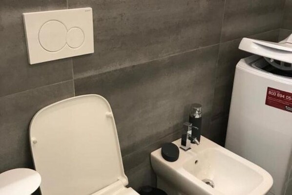A bathroom with a toilet, bidet, and a water heater.