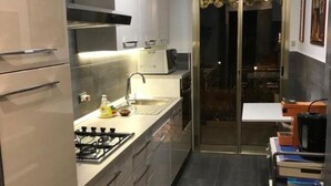 A compact kitchen with a gas stove, microwave, and modern cabinetry.