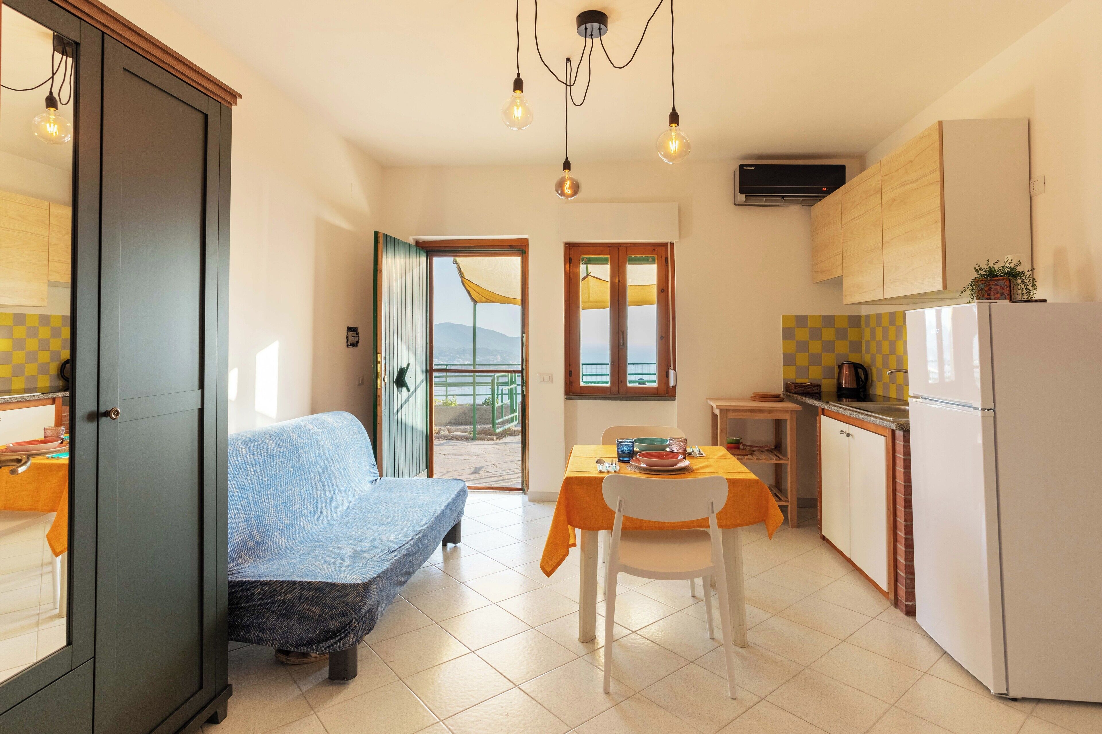 A compact living space with a sofa, a dining table, and a kitchen area.