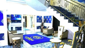 A luxurious interior with a blue carpet, gold accents, and a staircase. - G- throne Hotel and Suites (Port Harcourt)