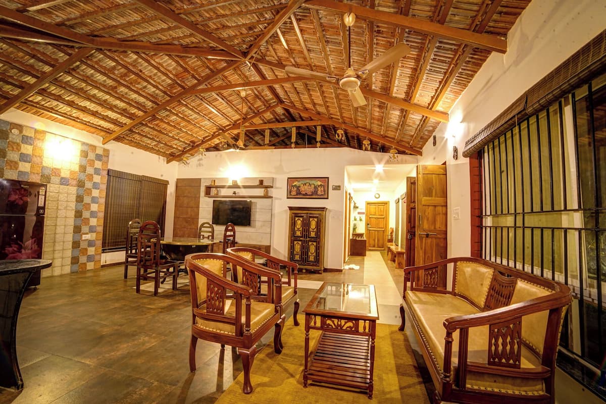 A spacious room with wooden furniture, a ceiling fan, and a tiled floor.