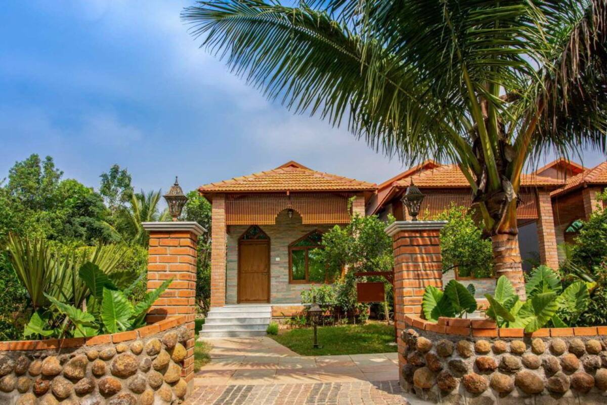 A traditional house with a tiled roof, brick walls, and a stone pathway leading to the entrance.