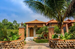 A traditional house with a tiled roof, brick walls, and a stone pathway leading to the entrance. - Brown Town Resort & Spa (Hyderabad)