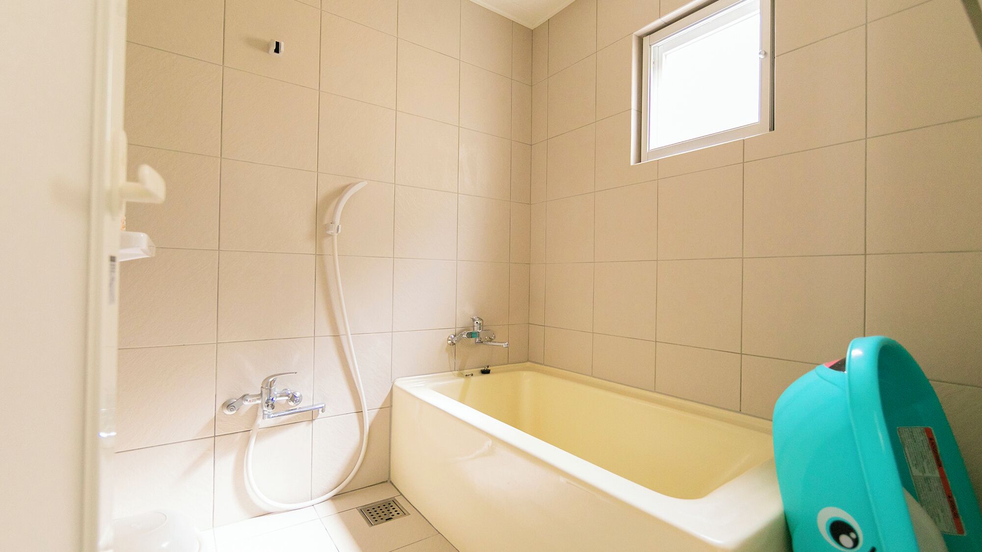 A bathroom with a bathtub, a shower, and a window.