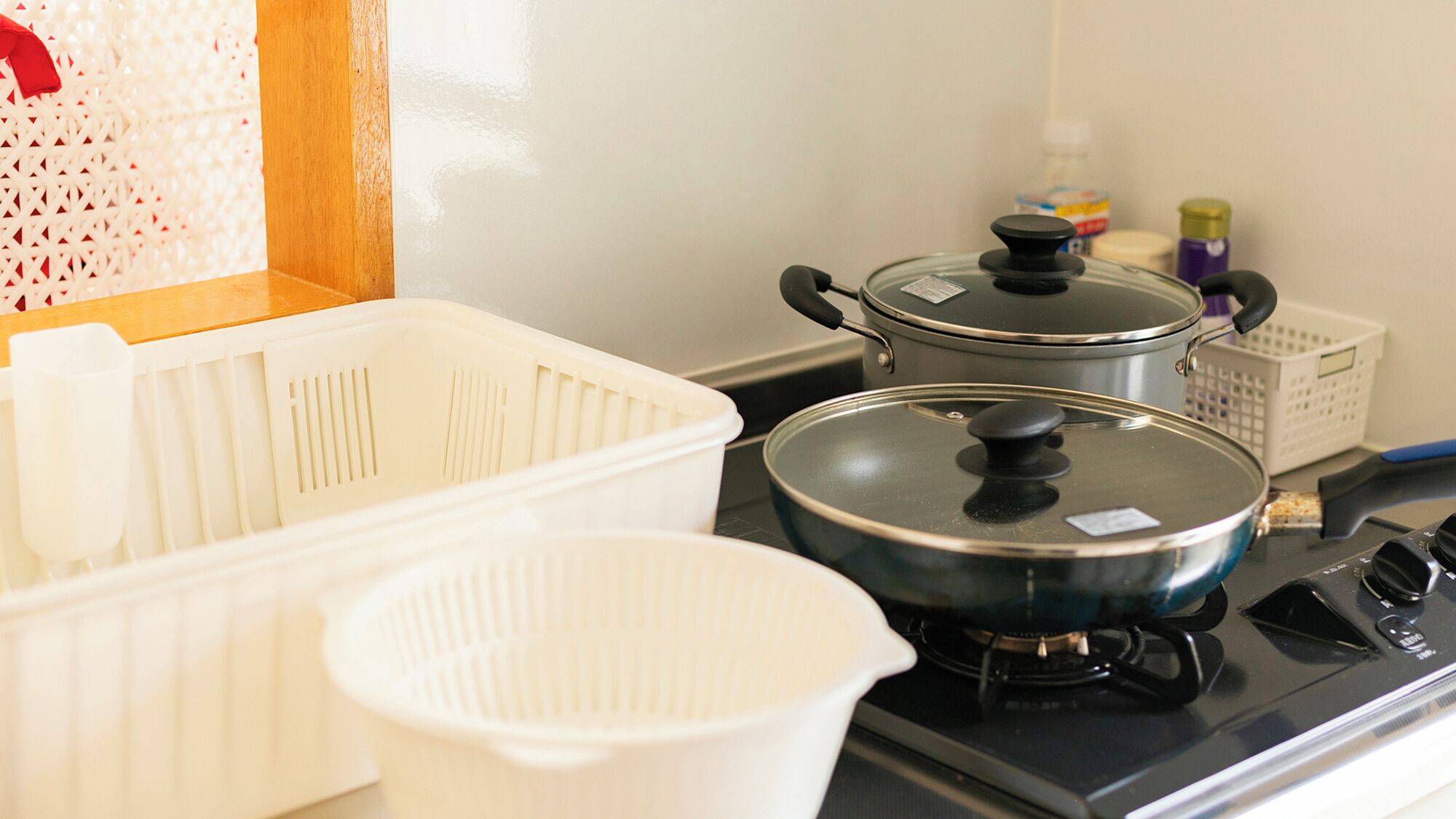 A kitchen with a stove, pots, and storage containers.