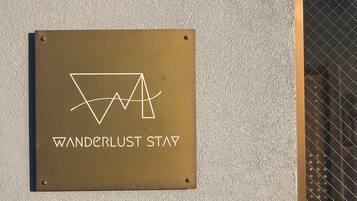 A sign with the text 'WANDERLUST STAY' and a stylized logo.