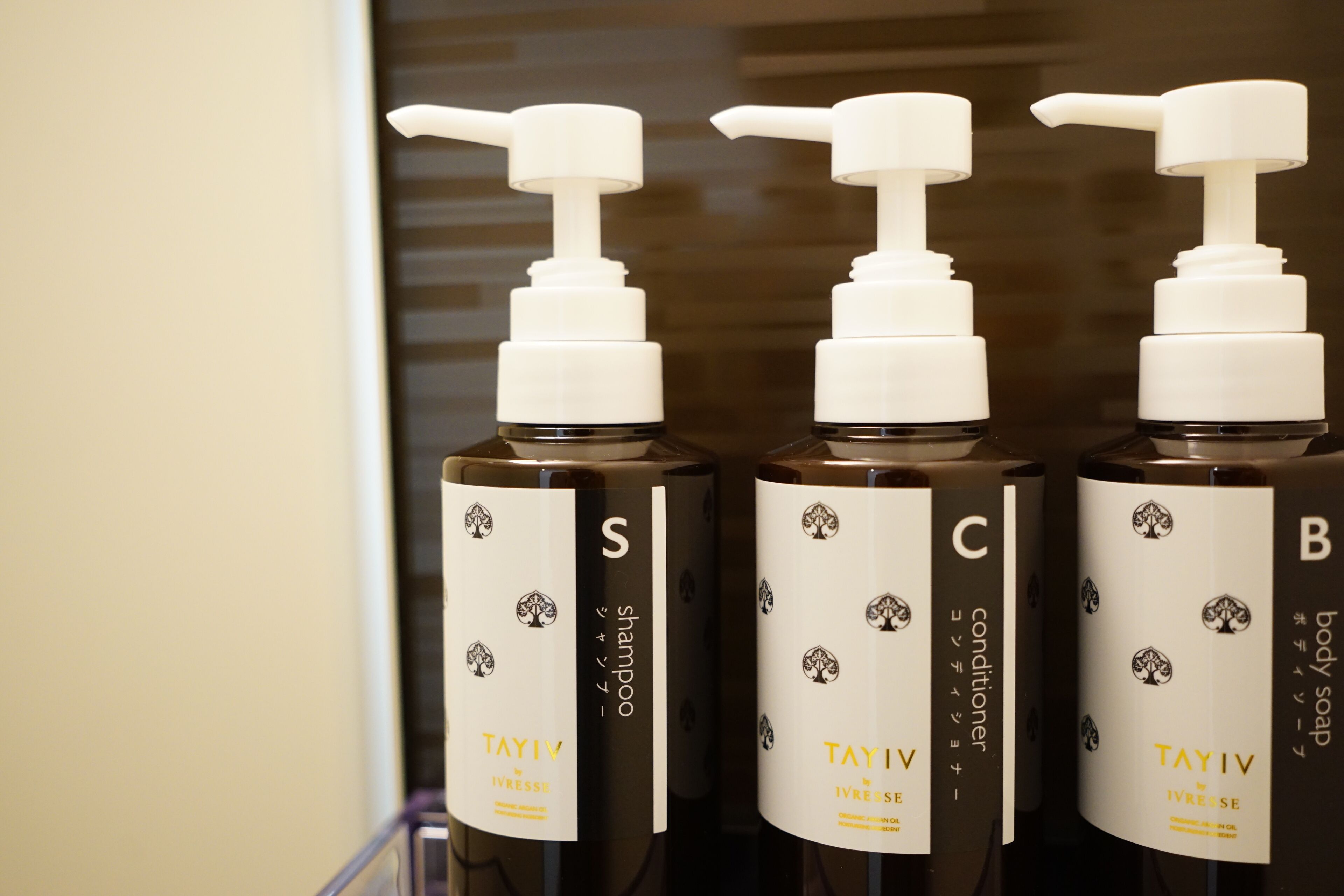 Three bottles of Tayiv body wash with pumps, labeled S, C, and B.