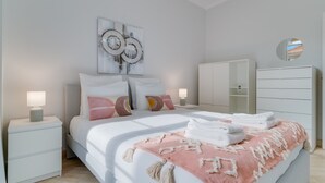 A modern bedroom with a bed, bedside tables, a wardrobe, and a mirror. - Funchal City Nest II (Funchal)