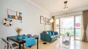 A modern living room with a dining table, sofa, and large windows. - Muchun Apartment (Guangzhou)