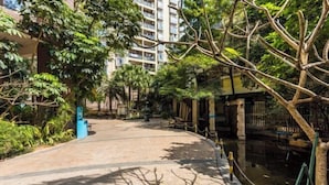 A pathway flanked by trees and a building with balconies. - Muchun Apartment (Guangzhou)