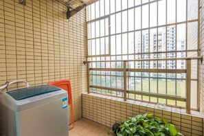 A room with a window, a radiator, and a plant. - Muchun Apartment (Guangzhou)