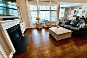 Un salon avec une cheminée, un canapé, une table basse et un téléviseur.