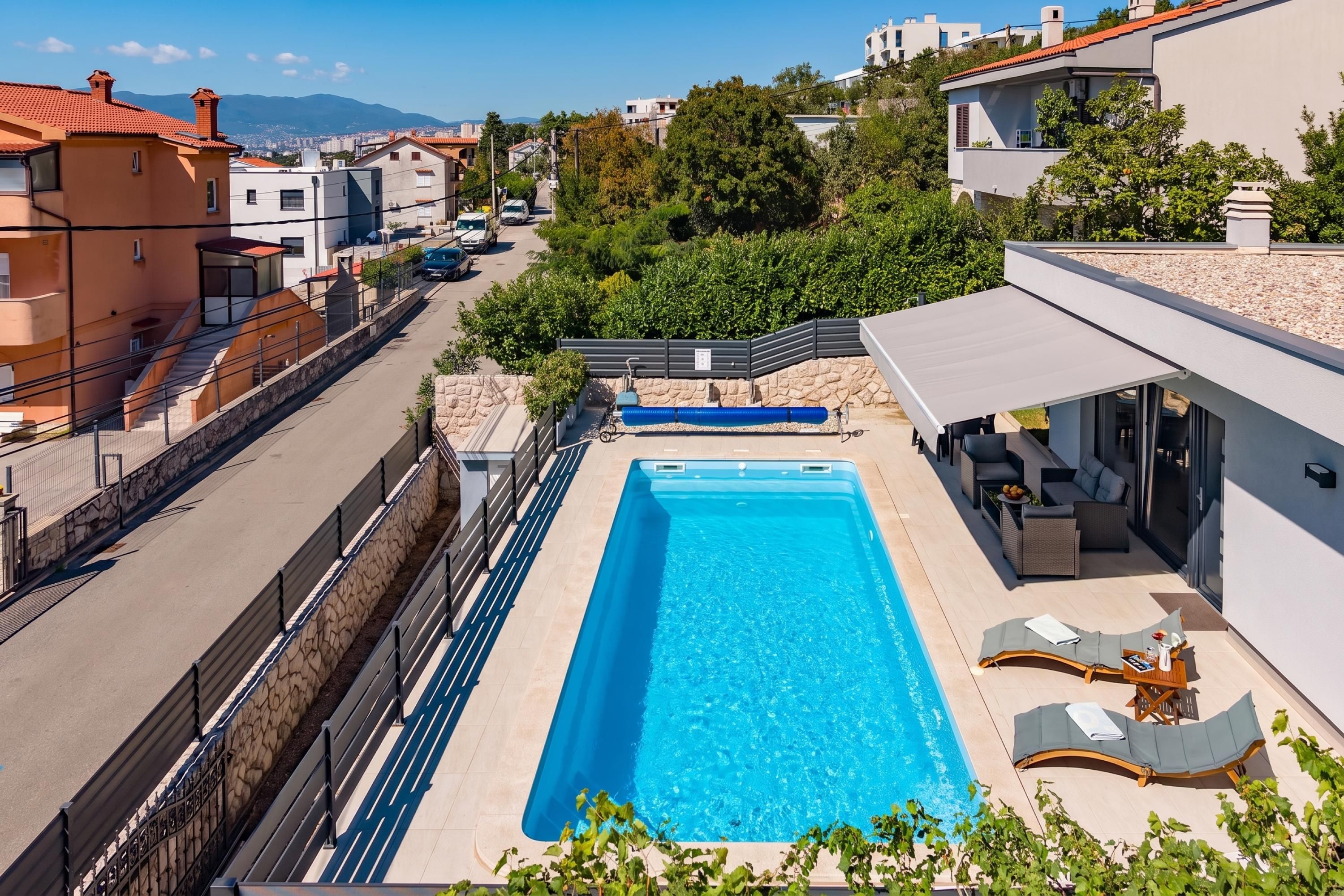 A rooftop swimming pool with a view of the cityscape.