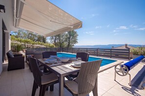 An outdoor dining area with a pool, overlooking a scenic landscape. - Holiday Home Sole (Kostrena)