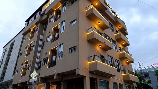 Un edificio de varios pisos con balcones, un restaurante en la planta baja y un letrero que dice 'BRAR PLAZA'.