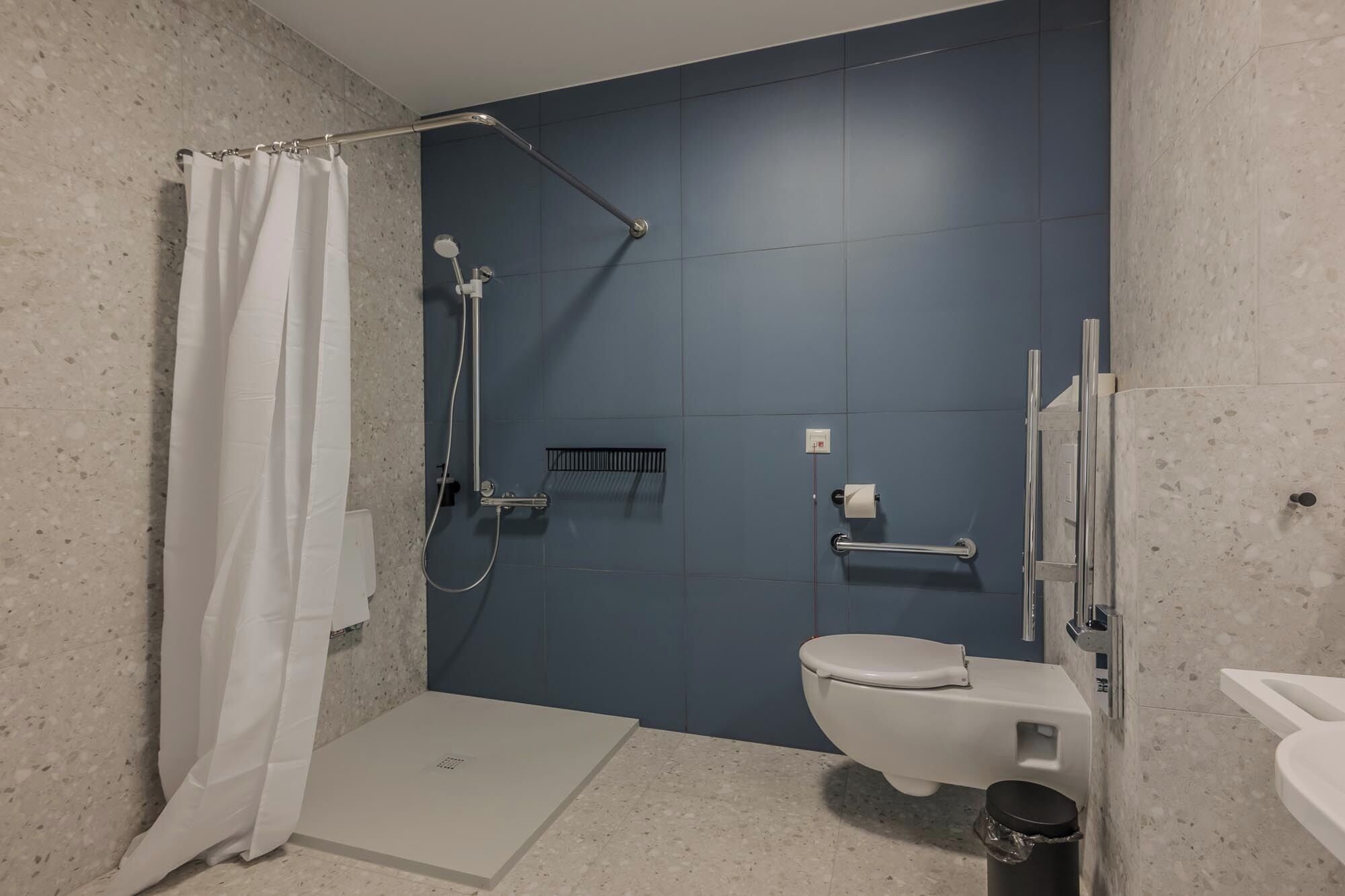 A bathroom with a shower, toilet, and sink.