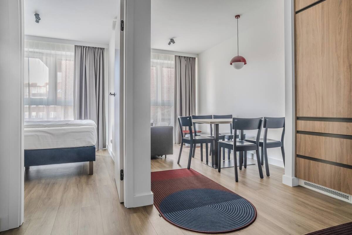 Een moderne hotelkamer met een bed, een bureau en een zithoek.