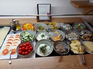 A buffet table with various food items and condiments. - Der Dolomitenhof  (Tristach)