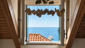 Ein Zimmer mit Meerblick durch ein Fenster mit einem dekorativen Vorhang.