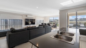 Un apartament modern amb zona de estar, menjador i cuina amb un gran finestral.