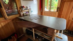 Une cuisine compacte dotée d’un plan de travail en bois, d’un petit évier et d’une étagère de rangement.