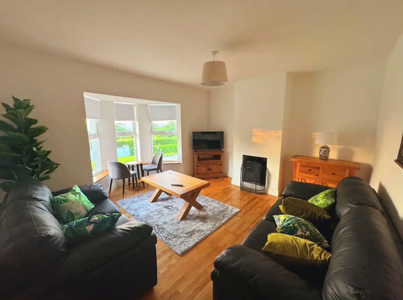 A living room with a sofa, a coffee table, a TV, and a fireplace.