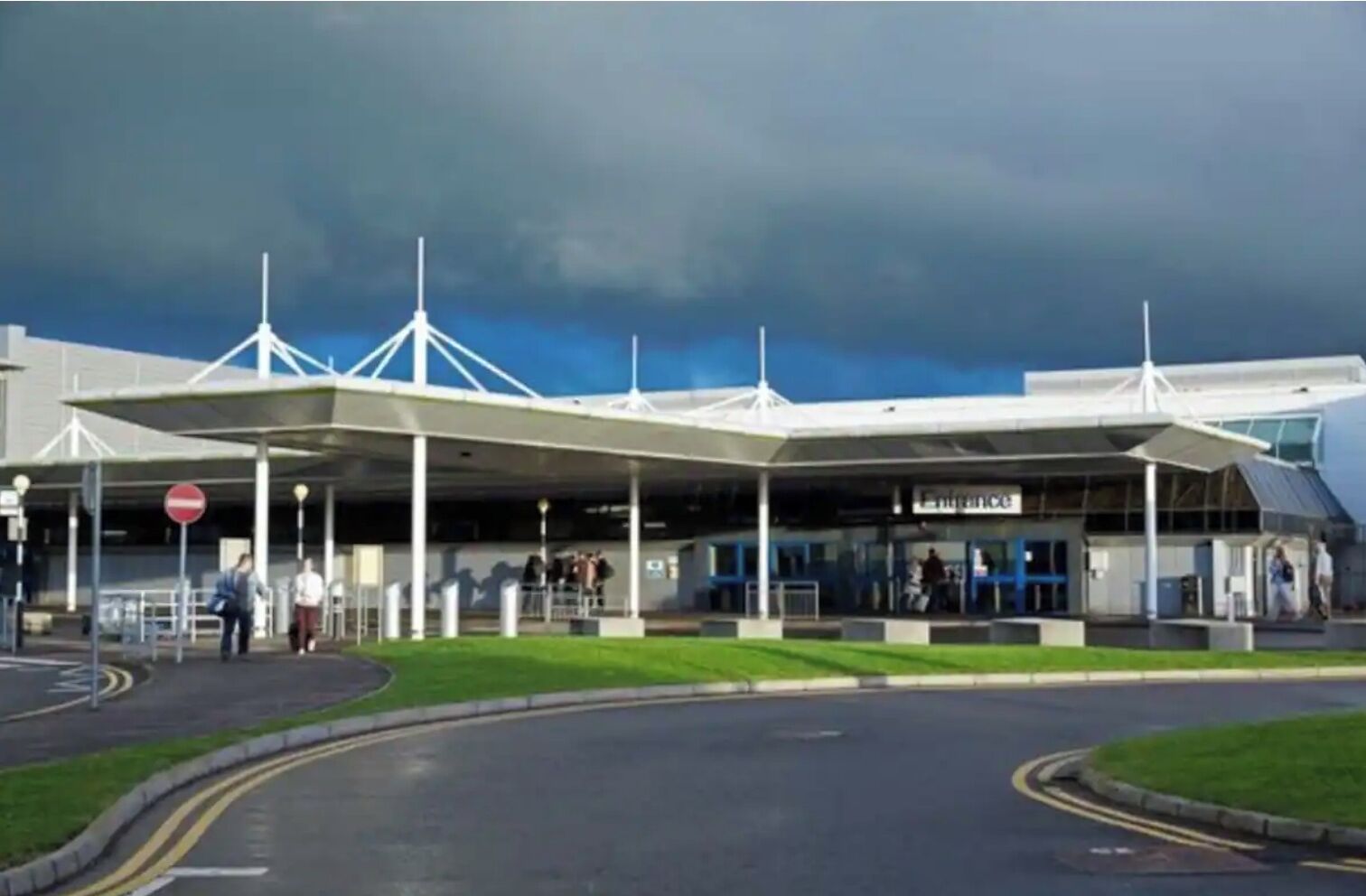 Un bâtiment moderne doté d’une entrée abritée et surplombant un ciel dégagé.
