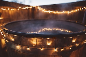 Un jacuzzi de madera con luces de cadena.