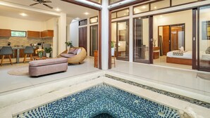 A spacious living area with a pool, a kitchen, and a bedroom with a large window. - The Seven Residence (Kerobokan)