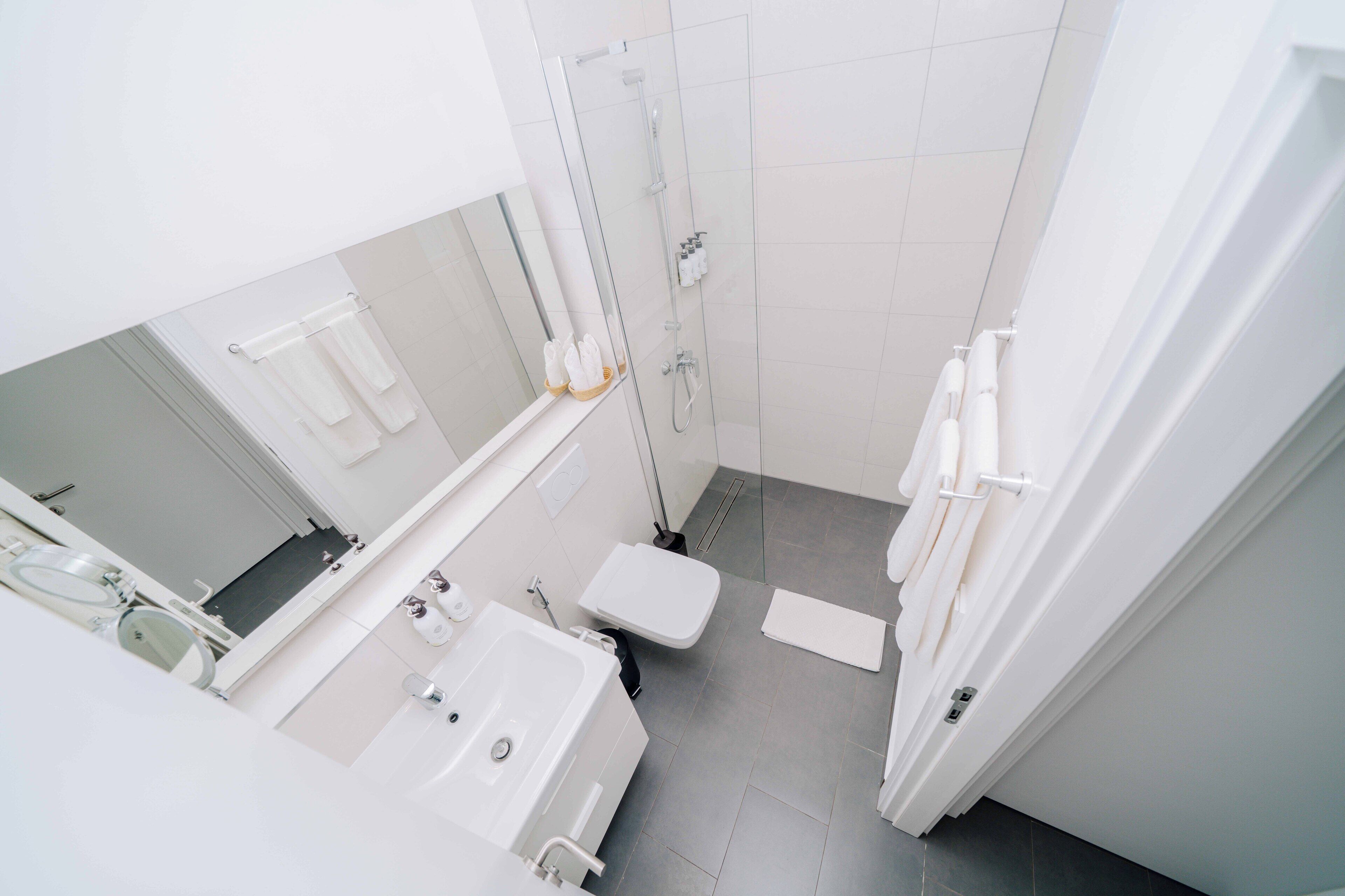 A modern bathroom with a bathtub, toilet, and shower area.