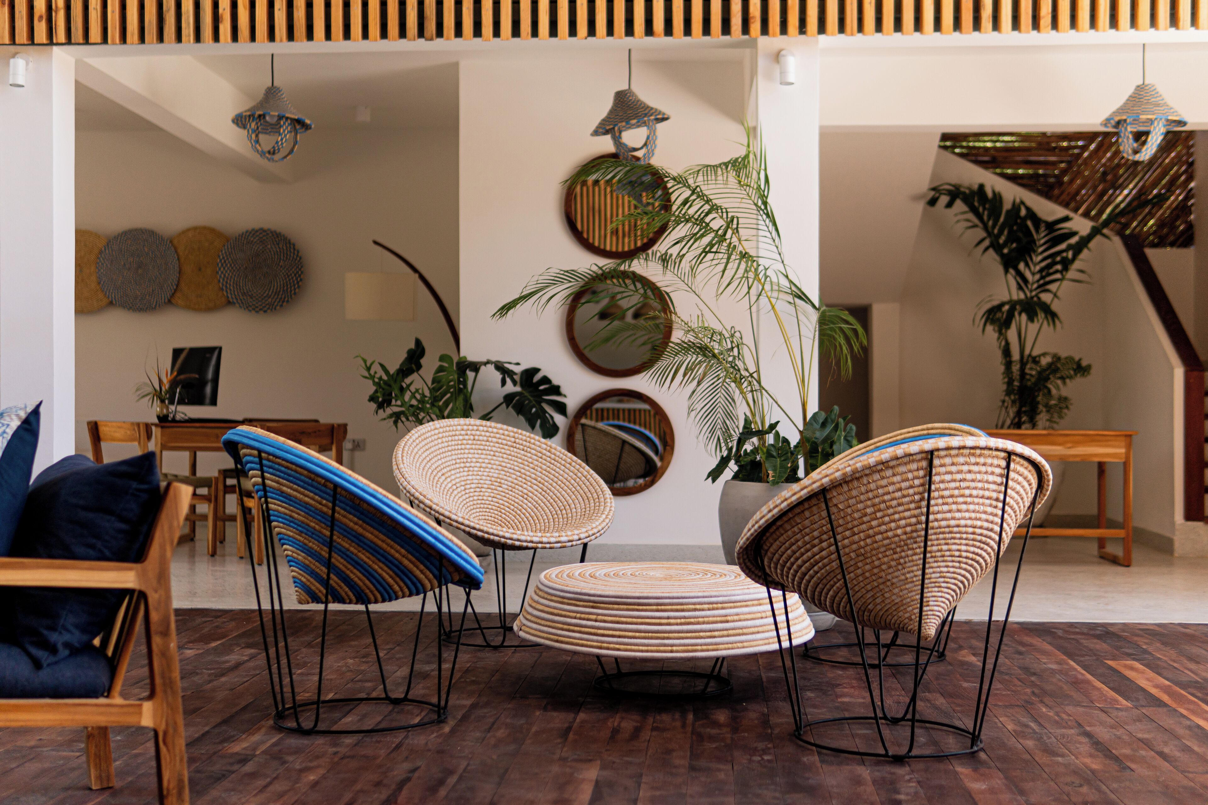 A modern living room with wicker furniture, a wooden floor, and decorative wall art.