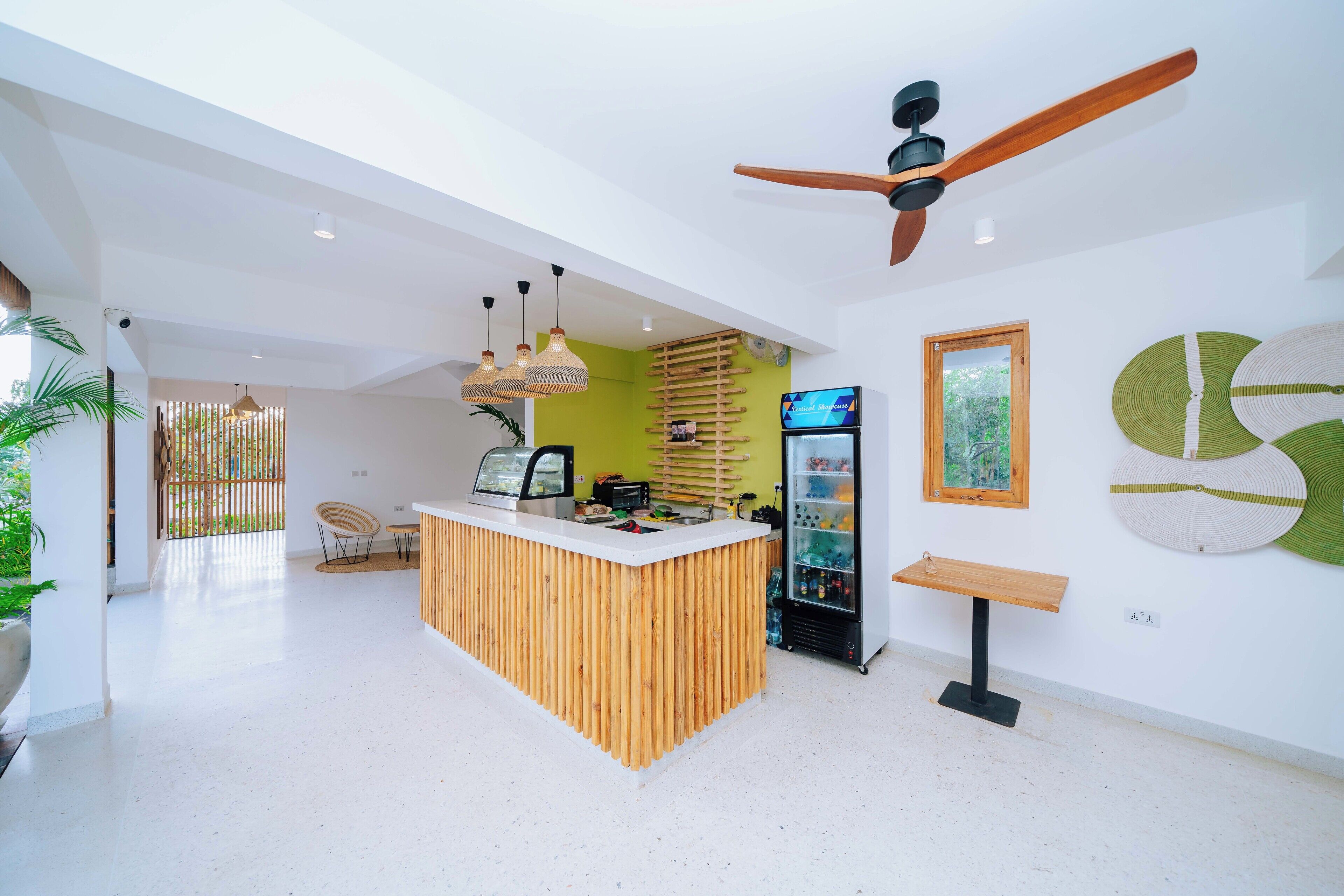 A modern kitchen with a wooden island, a ceiling fan, and a refrigerator.