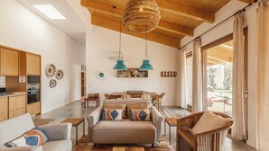 A spacious living area with a sofa, chairs, a dining table, and a large window with curtains. - TEIMA Alentejo SW (Odemira)