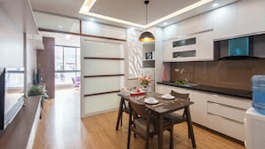 Una cocina moderna con zona de comedor, suelo de madera y un ventanal grande.