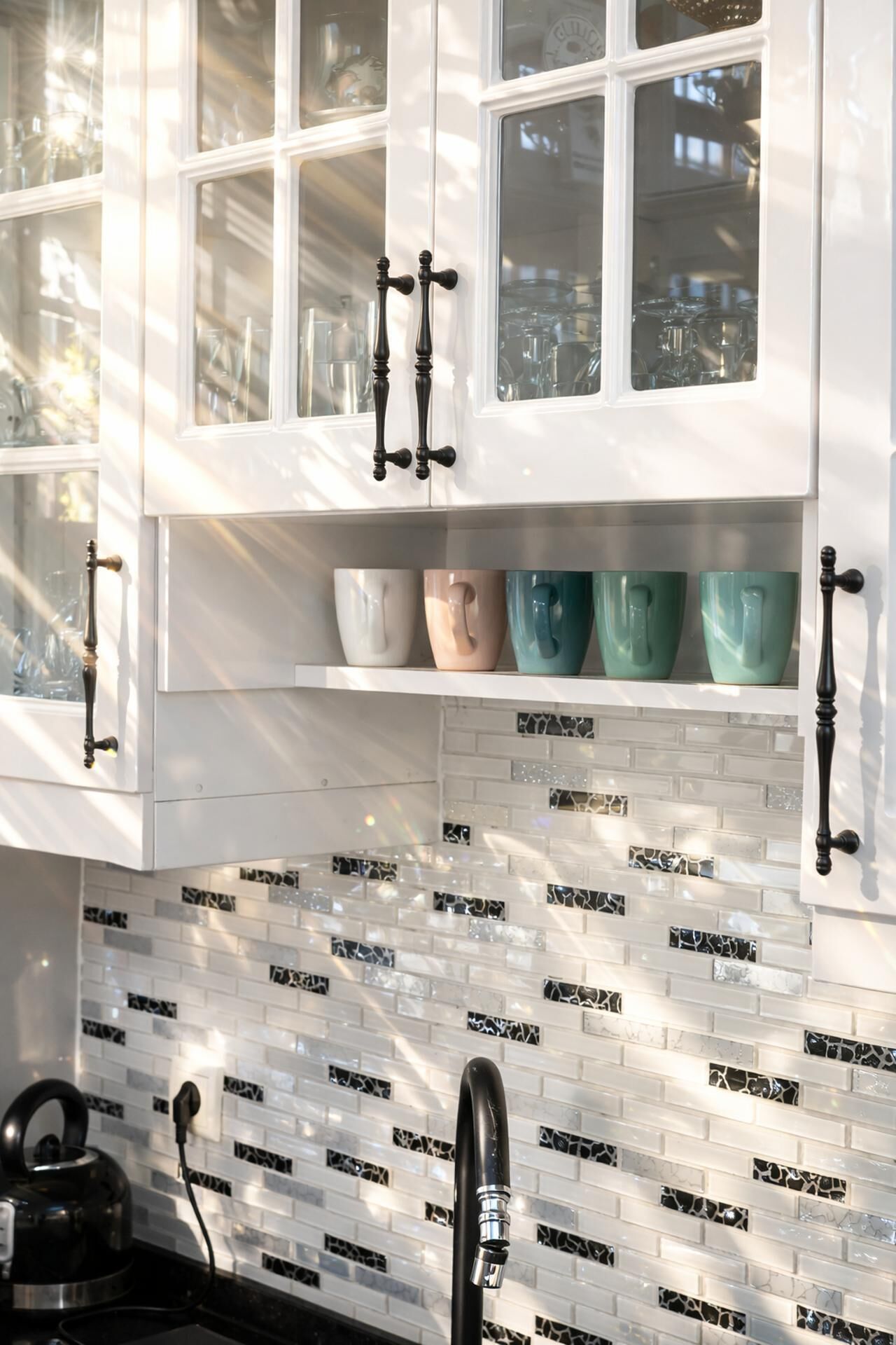 A kitchen with white cabinets, a tiled backsplash, and a coffee machine.