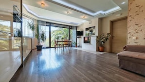 Un salón amplio con una mesa de comedor, sillas, un sofá y plantas en macetas.