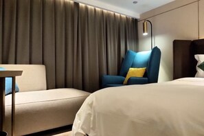 A hotel room with a bed, a sofa, a chair, and a table. - Yinjiang PLUS Hotel (Hangzhou)