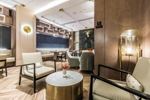 Un espace de détente moderne, doté de sièges, d’une table ronde et d’un mur décoratif.