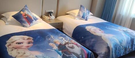 A hotel room with two beds, each with a 'Frozen' themed bedspread.