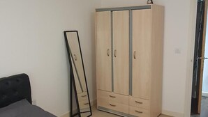 A bedroom with a bed, a wardrobe, and a mirror. - 1 Bed Apartment Sleeps 2 With Wi-fi & Tv (London)