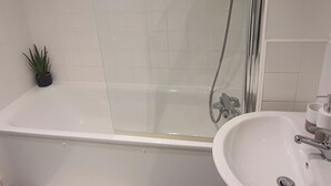A bathroom with a bathtub, shower, and sink. - 1 Bed Apartment Sleeps 2 With Wi-fi & Tv (London)