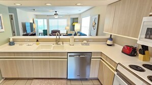 A modern kitchen with a dishwasher, stove, and a large island with a sink. - Fairways Paradise Walk-in Suite at the Fairways at Thousand Hills! Great Rates! (Branson)