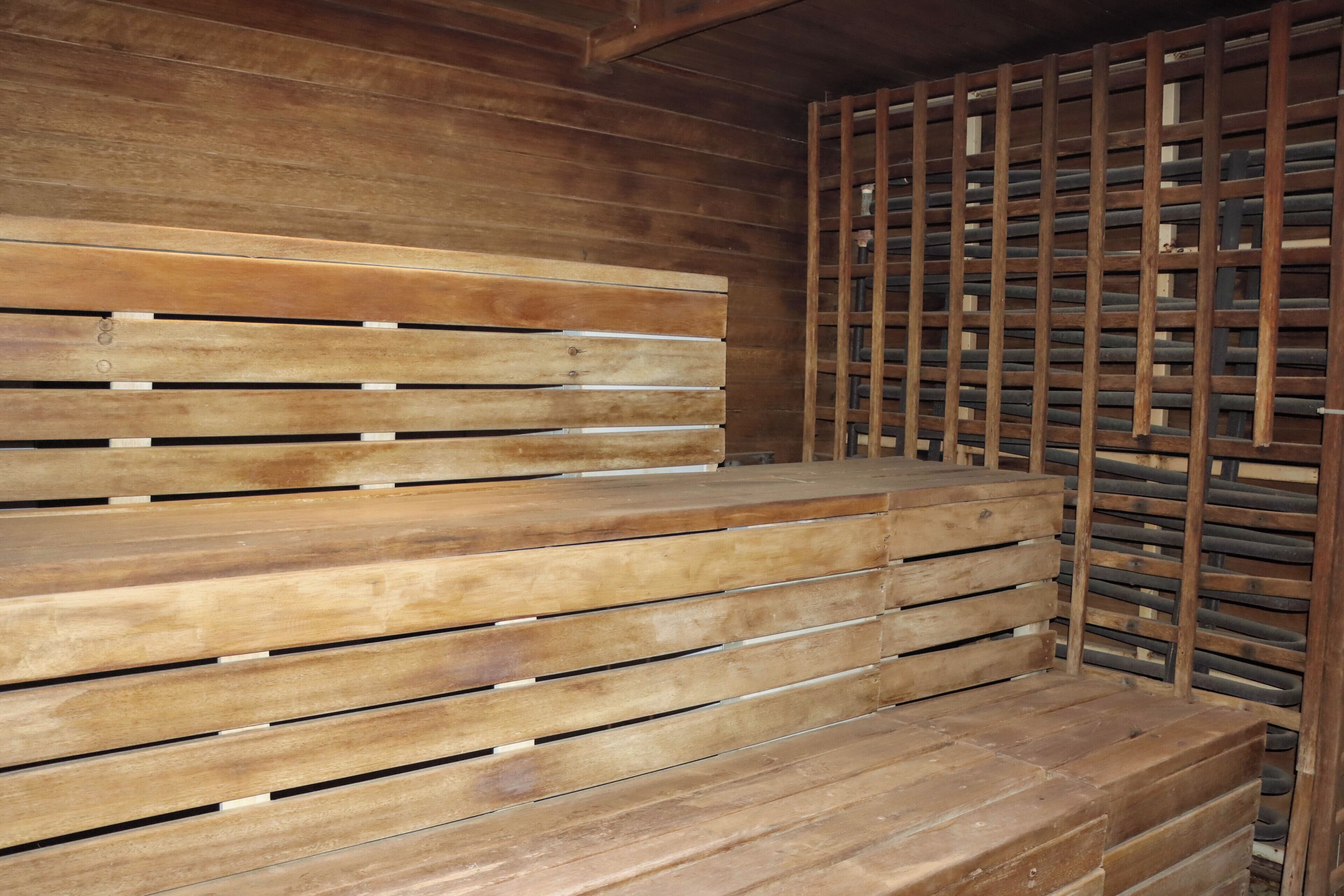 Un banco de madera con listones horizontales y una estructura metálica al fondo.