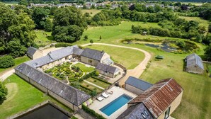 Una extensa propiedad con piscina, varias construcciones y amplios jardines.